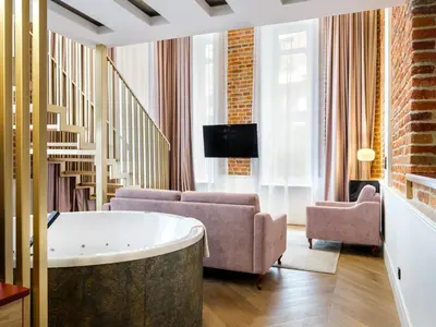 a living room with a tub and a couch and a tv at Golden Queen Deluxe Jacuzzi Apartments - Old Town in Kraków