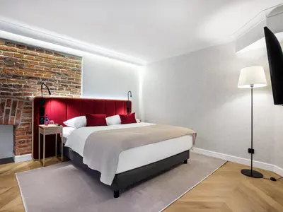 a bedroom with a large bed with a red headboard at Golden Queen Deluxe Jacuzzi Apartments - Old Town in Kraków