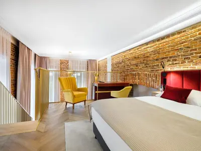 a hotel room with a bed and a brick wall at Golden Queen Deluxe Jacuzzi Apartments - Old Town in Kraków