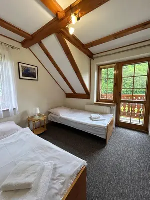 a bedroom with two beds and two windows at Pokoje Gościnne Młyn Bosaka in Ojców