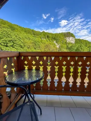 a wooden fence with a table on a balcony at Pokoje Gościnne Młyn Bosaka in Ojców
