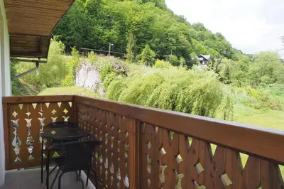a balcony with a table and a view of a field at Pokoje Gościnne Młyn Bosaka in Ojców