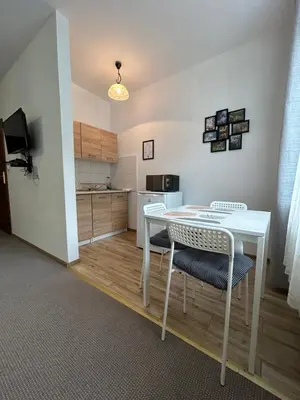a kitchen with a white table and two chairs at Pokoje Gościnne Młyn Bosaka in Ojców