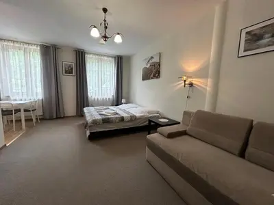 a living room with a couch and a bed at Pokoje Gościnne Młyn Bosaka in Ojców