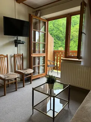 a living room with a tv and a glass table at Pokoje Gościnne Młyn Bosaka in Ojców