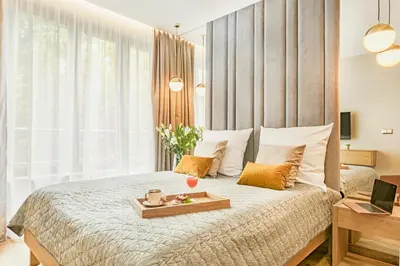 a bedroom with a bed with a tray of food on it at Golden Queen Apartments Old Town in Kraków