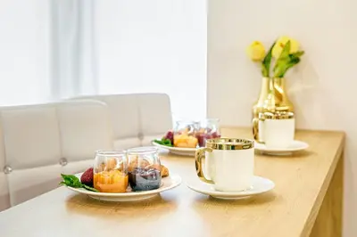 a wooden table with two plates of fruit and drinks at Golden Queen Apartments Old Town in Kraków