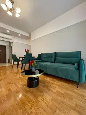 a living room with a green couch and a table at Golden Queen Apartments Old Town in Kraków