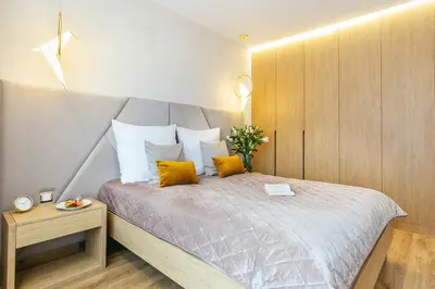 a bedroom with a large bed with yellow pillows at Golden Queen Apartments Old Town in Kraków