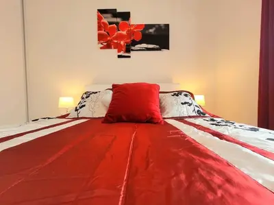 a bed with a red blanket on top of it at Apartment Sophie 3 rooms, 2 bathrooms, 8 persons in Kraków