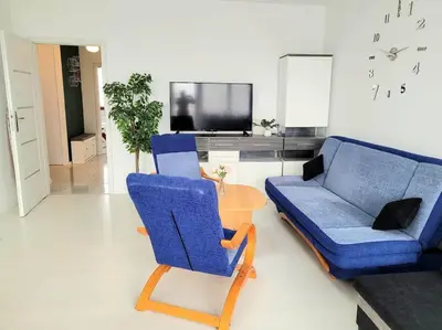 a living room with two chairs and a blue couch at Apartment Sophie 3 rooms, 2 bathrooms, 8 persons in Kraków