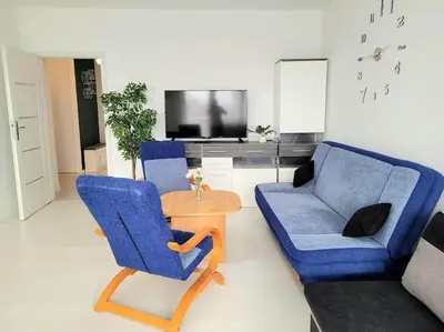 a living room with two blue chairs and a table at Apartment Sophie 3 rooms, 2 bathrooms, 8 persons in Kraków