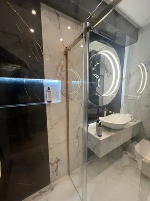a bathroom with a glass shower and a sink at CoCo Elite Apartments Zator in Zator