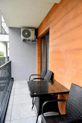 a patio with a table and chairs on a balcony at CoCo Elite Apartments Zator in Zator