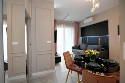 a kitchen with blue cabinets and a table with pink chairs at CoCo Elite Apartments Zator in Zator