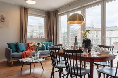 a dining room with a table and chairs and a couch at Tyzenhauz Apartments Arianska Street in Kraków