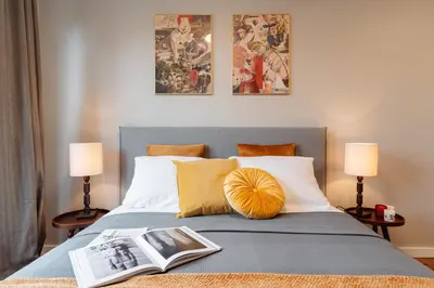 a bedroom with a bed with a book on it at Tyzenhauz Apartments Arianska Street in Kraków