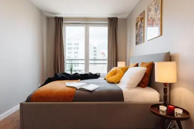 a bedroom with a bed with pillows and a window at Tyzenhauz Apartments Arianska Street in Kraków