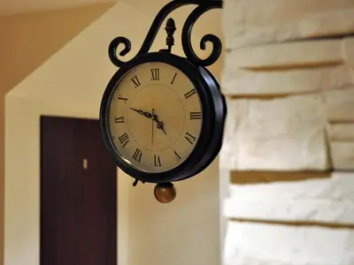 a clock hanging on a wall next to a door at Najlepsze Miejsce - pokoje i apartamenty w Krakowie in Kraków