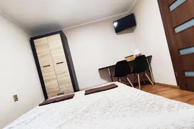 a bedroom with a bed and two chairs at Najlepsze Miejsce - pokoje i apartamenty w Krakowie in Kraków