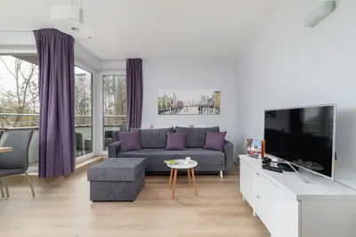 a living room with a couch and a tv at Cystersów Apartment Cracow by Noclegi Renters in Kraków