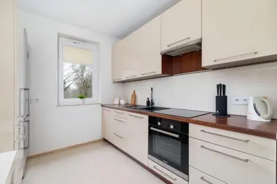 a kitchen with white cabinets and a window at Cystersów Apartment Cracow by Noclegi Renters in Kraków