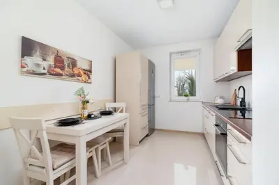 a white kitchen with a white table and chairs at Cystersów Apartment Cracow by Noclegi Renters in Kraków