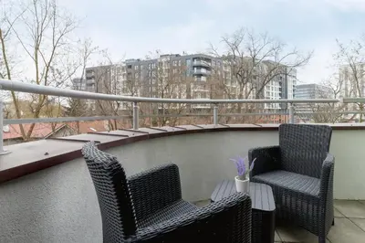 two chairs and a table on a balcony at Cystersów Apartment Cracow by Noclegi Renters in Kraków