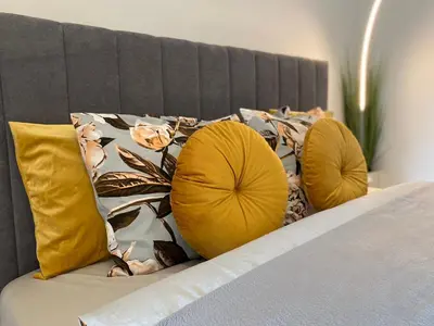 a bed with two yellow pillows on top of it at Podskale Apartment in Kraków