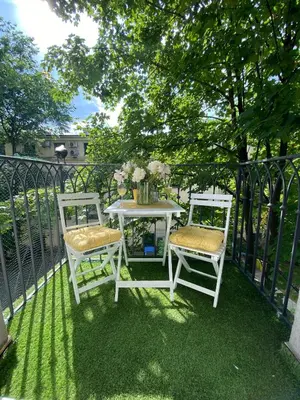 two white chairs and a table on a balcony at Podskale Apartment in Kraków