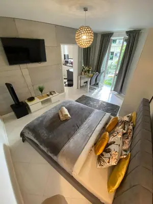 a bedroom with a large bed and a living room at Podskale Apartment in Kraków