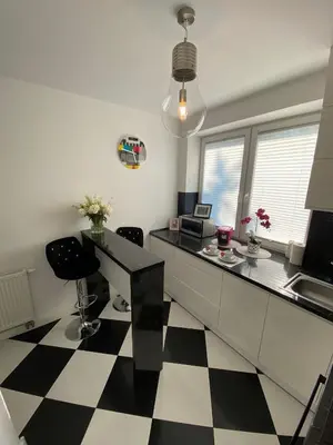 a kitchen with a black and white checkered floor at Podskale Apartment in Kraków