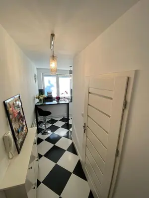 a room with a hallway with a door and a desk at Podskale Apartment in Kraków