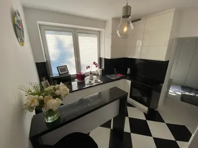 a kitchen with a counter with a vase of flowers at Podskale Apartment in Kraków