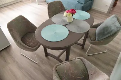 a table with chairs and a vase of flowers on it at Apartament Emmi in Imielin
