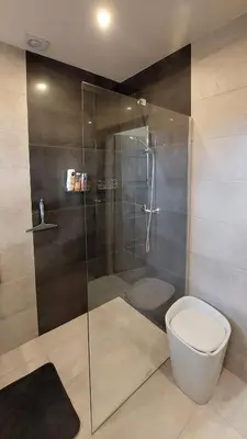 a bathroom with a toilet and a glass shower at Apartament Emmi in Imielin