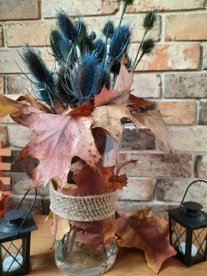 a vase filled with feathers and autumn leaves at Apartament Emmi in Imielin