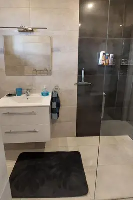 a bathroom with a shower and a sink and a mirror at Apartament Emmi in Imielin