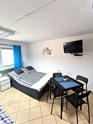 a bedroom with a bed and a table with chairs at Wyspani Zator in Zator