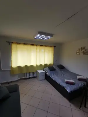 a bedroom with a bed and a yellow curtain at Wyspani Zator in Zator