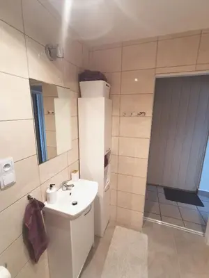 a white bathroom with a sink and a mirror at Wyspani Zator in Zator