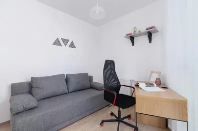 a living room with a couch and a desk and a chair at Family Apartment with Parking & Terrace by Noclegi Renters in Kraków