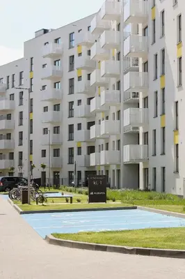 a large apartment building with a sign in front of it at Family Apartment with Parking & Terrace by Noclegi Renters in Kraków