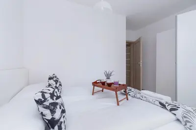 a white room with a bed and a table at Family Apartment with Parking & Terrace by Noclegi Renters in Kraków