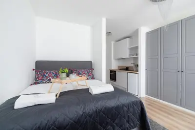a bedroom with a black bed with a table on it at Elegant Pet-Friendly Studio in Krakow by Noclegi Renters in Kraków