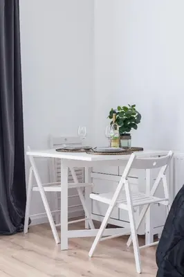 a white table with a plant on top of it at Elegant Pet-Friendly Studio in Krakow by Noclegi Renters in Kraków