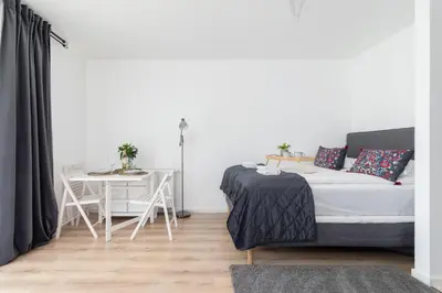 a living room with a bed and a table at Elegant Pet-Friendly Studio in Krakow by Noclegi Renters in Kraków