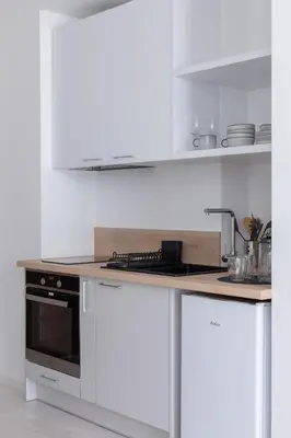 a kitchen with white cabinets and a stove top oven at Elegant Pet-Friendly Studio in Krakow by Noclegi Renters in Kraków