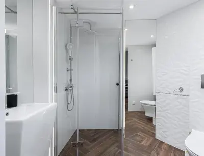 a white bathroom with a shower and a toilet at Vistula Boulevards Jacuzzi Apartment in Kraków