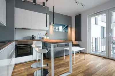 a kitchen with a table and chairs in a room at Modern and comfortable with a bedroom in Kraków